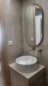 La salle de bains est pourvue d'un lavabo et d'un miroir. dans l'établissement Φιλόξενο σπίτι στο Βόλο, à Vólos