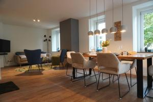 comedor y sala de estar con mesa y sillas en Sleepwell Apartment - Ehrensteinsuite, en Leipzig