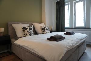 1 dormitorio con 1 cama con 2 toallas en Sleepwell Apartment - Ehrensteinsuite, en Leipzig