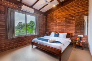 een slaapkamer met een bed in een bakstenen muur bij SaffronStays Willowbrook Arbor, Nashik in Nashik