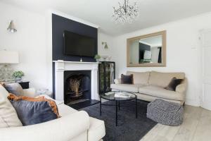 a living room with two couches and a fireplace at The Kept Cottage in Hassocks
