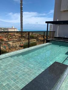 a swimming pool on top of a building at Reserva Madero Requinte Apto 104 in Natal