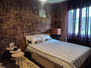 a bedroom with a bed and a brick wall at Etno selo naša avlija in Blace