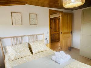a bedroom with a bed with two towels on it at Casa Neto Goje in San Tirso de Abres