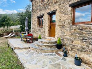 a stone house with a stone pathway leading to a patio at Casa Neto Goje in San Tirso de Abres
