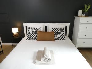 a bedroom with a white bed with black and white pillows at Clichy-Levallois Bords de Seine in Clichy