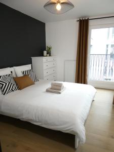 a bedroom with a large white bed and a window at Clichy-Levallois Bords de Seine in Clichy