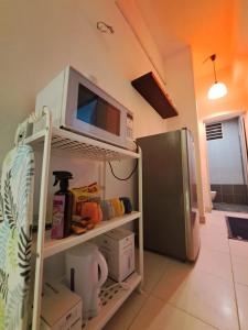 eine Küche mit einer Mikrowelle auf dem Kühlschrank in der Unterkunft LED Homestay in Shah Alam