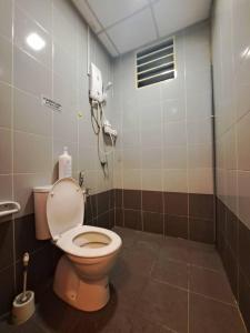 ein Bad mit WC und ein Telefon an der Wand in der Unterkunft LED Homestay in Shah Alam