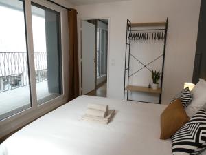ein Schlafzimmer mit einem weißen Bett und einem großen Fenster in der Unterkunft Clichy-Levallois Bords de Seine in Clichy
