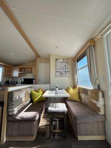 a living room with two couches and a table at Lyons Robin Hood Coastal Holiday Park, Savannah in Rhyl