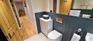 een blauwe badkamer met een toilet en een wastafel bij The School House, Sowood, Halifax in Halifax