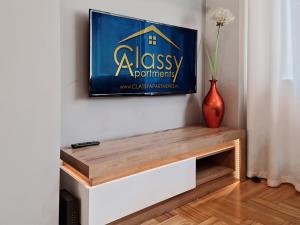Telewizor wiszący na ścianie z wazonem w obiekcie CLASSY APARTMENTS - Gdynia - Słoneczny w mieście Gdynia