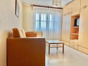 a living room with a couch and a table at Apartamentos Los Arces in Isla