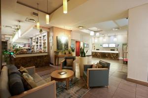 a lobby with couches and chairs and a table at Protea Hotel by Marriott Cape Town North Wharf in Cape Town