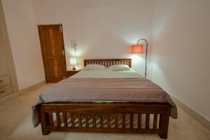 a bedroom with a large bed with a lamp on it at HomeSlice Nazaara, HomeStay in BTM in Bangalore