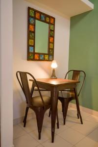 a table and two chairs with a lamp and a mirror at HomeSlice Nazaara, HomeStay in BTM in Bangalore