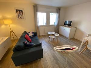 uma sala de estar com um sofá e uma mesa em COSY CONFORT LA PEROUSE 1A coeur de ville et plage em Concarneau