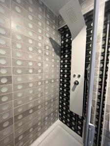 een badkamer met een douche met zwarte en witte tegels bij Appartement 4 personnes, aéroport Marseille in Marignane