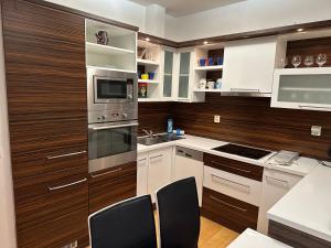 a kitchen with white and brown cabinets and a sink at Apartments Spačilova nearly center in Komárov
