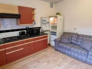 a small kitchen with a couch and a refrigerator at Spacious Flat Near Rochdale Centre Self Check-in Free Parking & Fast Wi-Fi in Rochdale