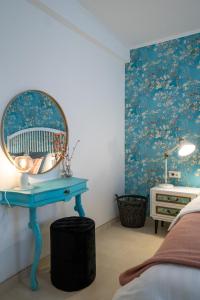 a bedroom with a blue dressing table and a mirror at VINCENT Studio Apartment in Rijeka