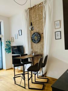 a dining room table with chairs and a clock on a wall at Rittertal in Altmünster