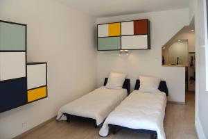 duas camas num quarto com pinturas na parede em Le 38 derrière l'église em Clairvaux-les-Lacs