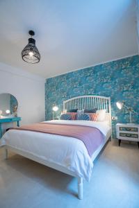 a bedroom with a large bed with a blue wall at VINCENT Studio Apartment in Rijeka