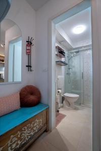 a bathroom with a bench with a mirror and a toilet at VINCENT Studio Apartment in Rijeka