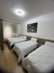 duas camas num quarto com lençóis brancos em Your Joyful Spot em Shkodër