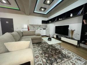 uma sala de estar com um sofá e uma televisão em Your Joyful Spot em Shkodër
