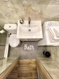 łazienka z umywalką i znakiem kąpielowym na ścianie w obiekcie Apartament Centrum w Supraślu
