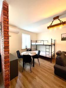 a living room with a table and chairs and a bunk bed at Apartament Centrum in Supraśl