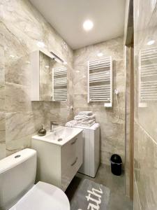 La salle de bains est pourvue de toilettes blanches et d'un lavabo. dans l'établissement Apartament Centrum, à Supraśl