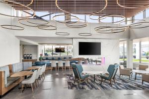 eine Lobby mit Tischen und Stühlen und einem Flachbild-TV in der Unterkunft Residence Inn by Marriott Laval in Laval