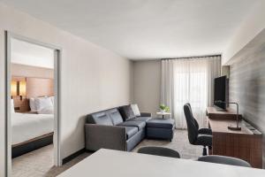 a hotel room with a bed and a living room at Residence Inn by Marriott Laval in Laval