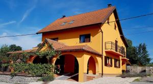 a yellow house with a brown roof at 4 you in Lovinac