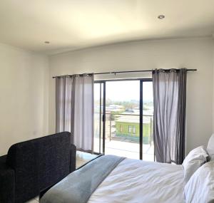 een slaapkamer met een bed en een groot raam bij H&H Self-catering in Windhoek