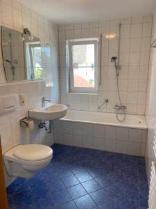a bathroom with a toilet and a sink and a bath tub at Harmony Apartment, your holiday home in Rust with balcony & river-view, 5min to Europa-Park in Rust