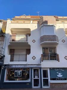 un alto edificio bianco con finestre e balconi di Appart duplex hypercentre 8 pers , petite vue mer a Le Touquet-Paris-Plage
