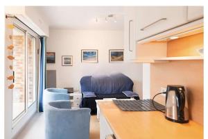 una cucina con sedie blu e una scrivania con computer di Appart duplex hypercentre 8 pers , petite vue mer a Le Touquet-Paris-Plage