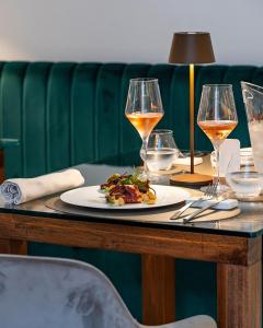 - une table avec une assiette de nourriture et des verres à vin dans l'établissement Villa Rosa Antico Dimora Storica, à Otrante