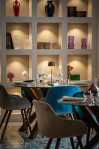 - une salle à manger avec une table, des chaises et des verres à vin dans l'établissement Villa Rosa Antico Dimora Storica, à Otrante