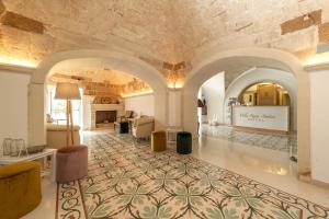 une grande chambre avec un mur en pierre et un salon dans l'établissement Villa Rosa Antico Dimora Storica, à Otrante