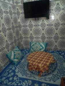 a table with a plate and a television on a wall at taghazout agadir appartement familiale in Taghazout
