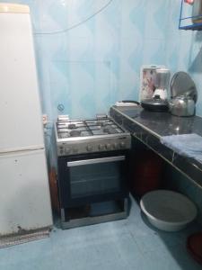 a small kitchen with a stove and a counter top at taghazout agadir appartement familiale in Taghazout