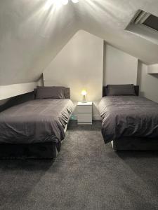 two beds in a room with a attic at Juz Apartments Manchester airport in Altrincham