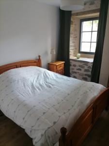 ein Schlafzimmer mit einem großen Bett und einem Fenster in der Unterkunft Relais des Gorges de la Truyère in Anglards-de-Saint-Flour