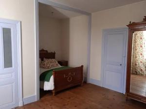 een slaapkamer met een bed en een grote spiegel bij Chateau de Maisonneuve 